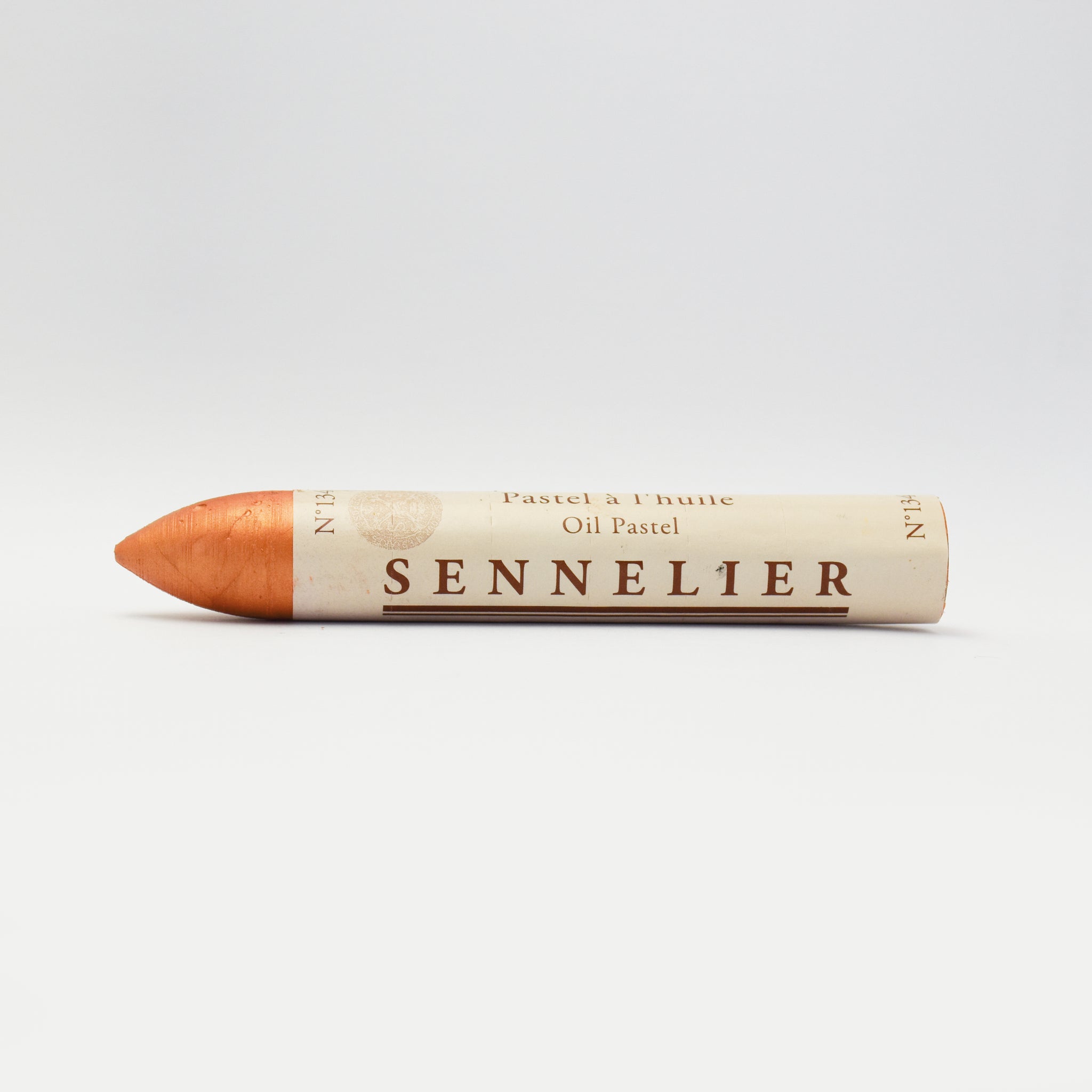 A single Sennelier oil pastel crayon against a white background, displaying the brand name and the word 'Oil Pastel' on the wrapper.