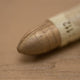 A close-up of a Sennelier oil pastel on a metallic gold background.