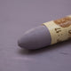 A close-up of a Sennelier oil pastel on a  Violet Grey background.