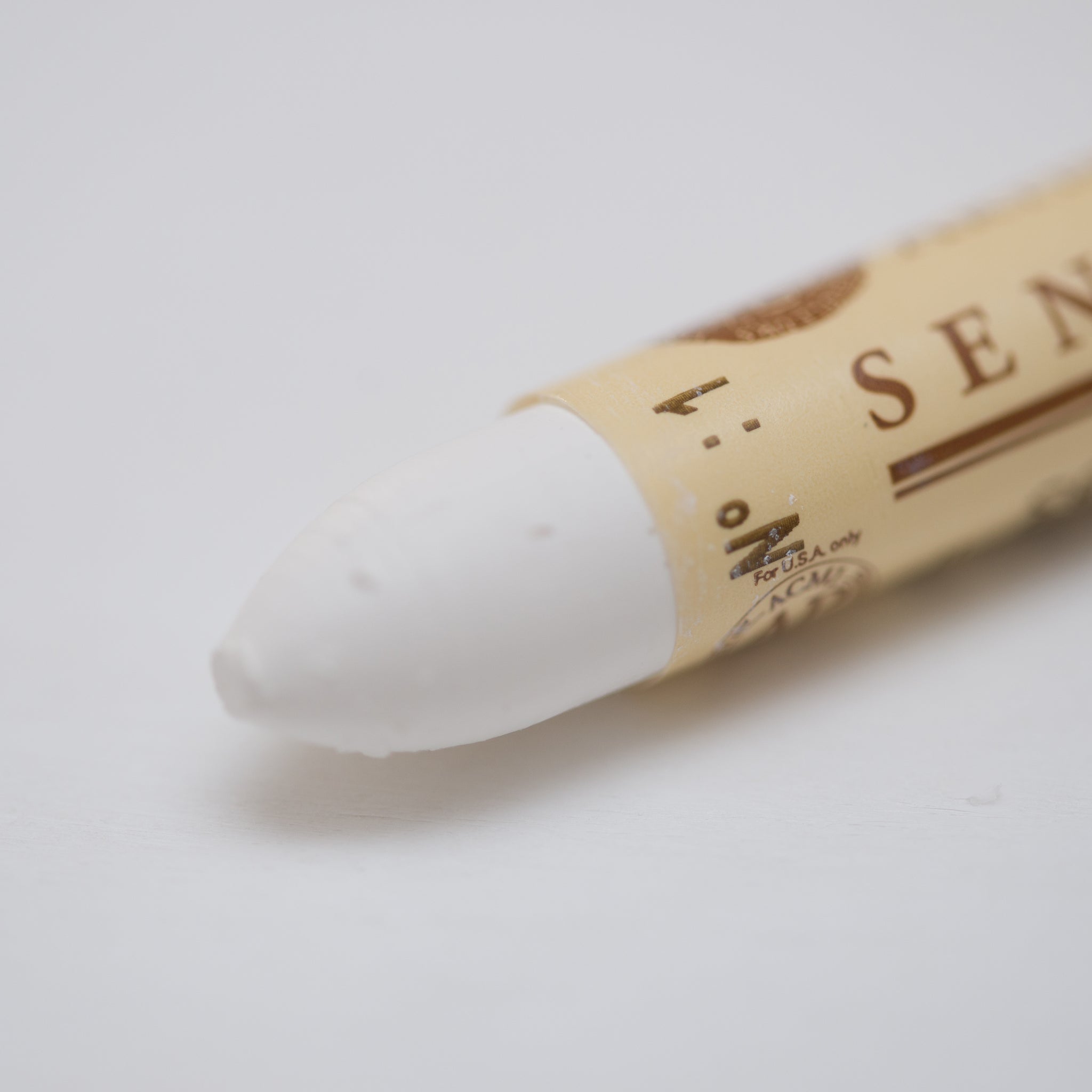 A close-up of a Sennelier oil pastel on a White background.