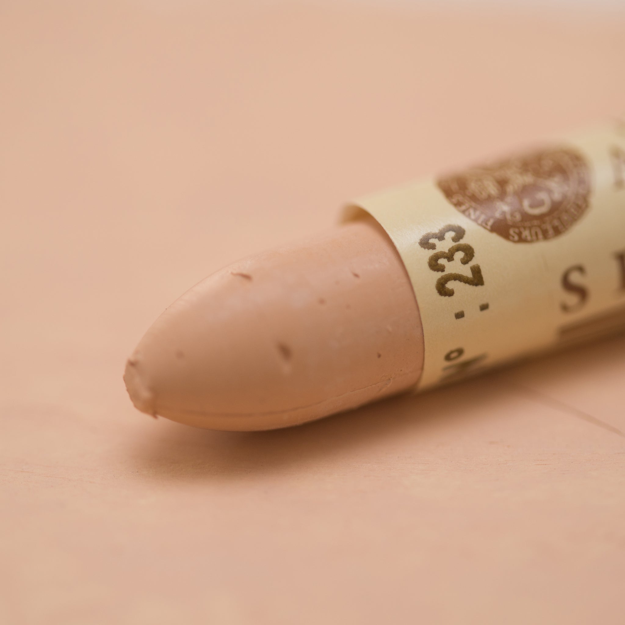 A close-up of a Sennelier oil pastel on a  soft brown background.