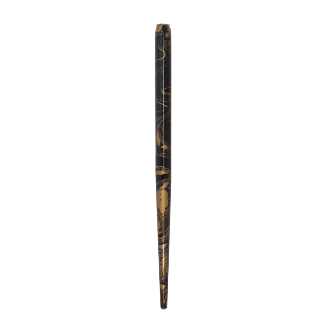 A traditional nib holder with a swirled gold design on a black surface