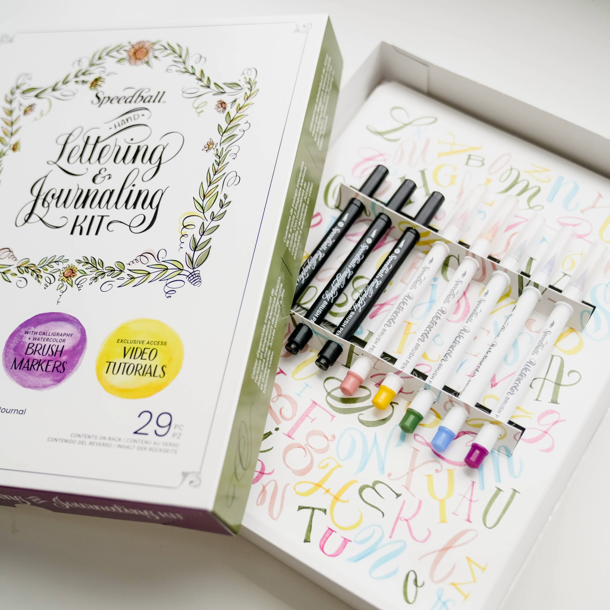 Lettering and journaling kit with markers and packaging on a white background