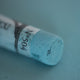 A close-up of a blue Sennelier extra soft pastel. on the same coloured background, with the colour information printed on the paper wrap.