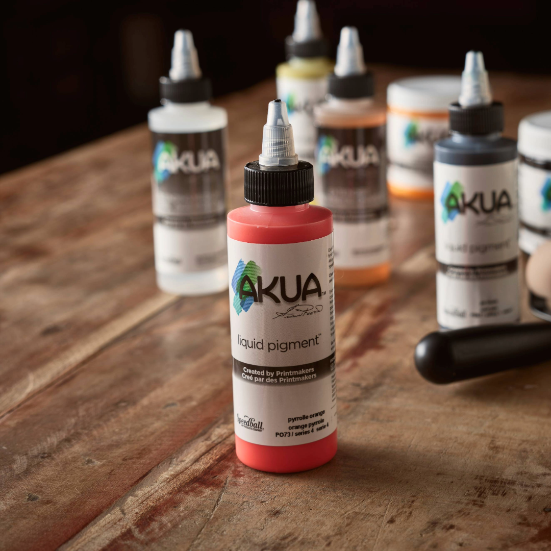 Akua liquid pigment bottles on a wooden surface