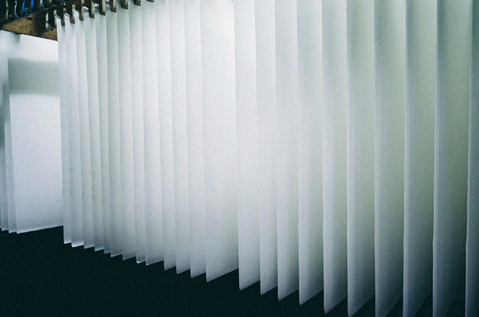 White paper sheets hanging from a rail system