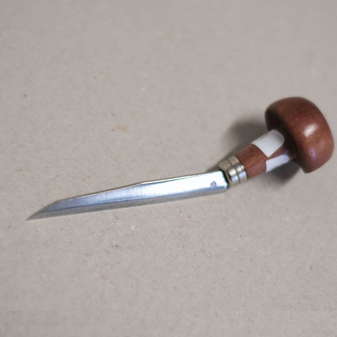 An E C Lyons Elliptical Tint Tool with a wooden handle and a steel blade, lying on a beige surface.