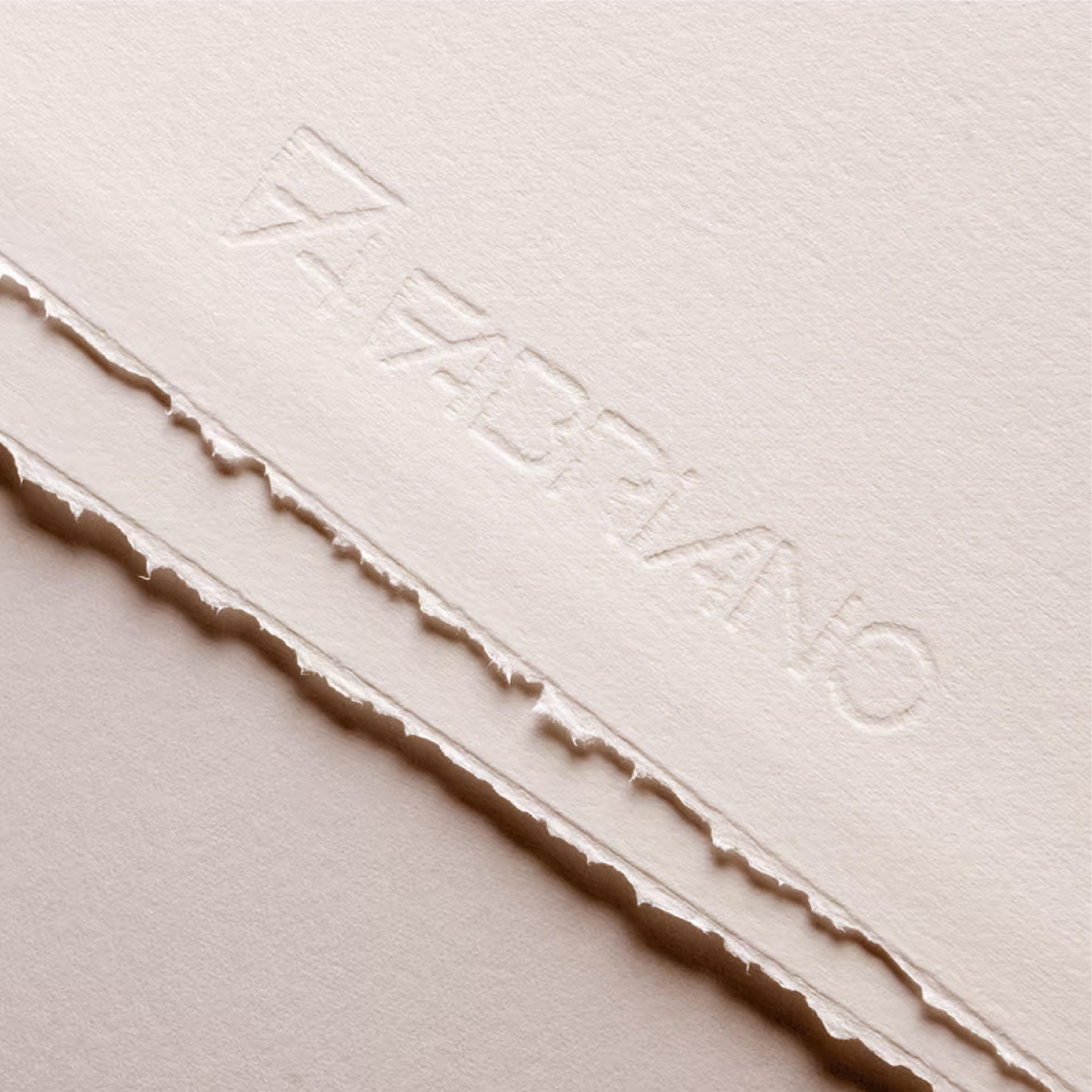 Close-up image of Fabriano Rosaspina papers showing its texture and deckled edges as well as the watermark featuring the Fabriano logo and brand name.