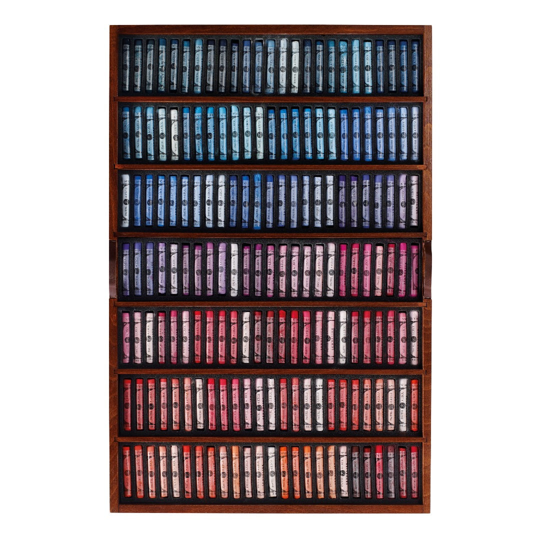 a wooden tray of soft pastels in varying colours displayed on a white background