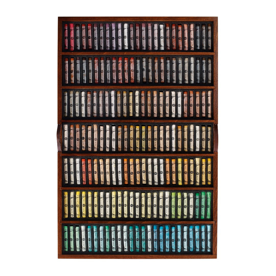 a wooden tray of soft pastels in varying colours displayed on a white background