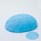 A half egg shaped pastel in a light blue tone, sitting on a white background with a drawn colour swatch.
