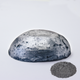 A half egg shaped pastel in a graphite  tone, sitting on a white background with a drawn colour swatch.