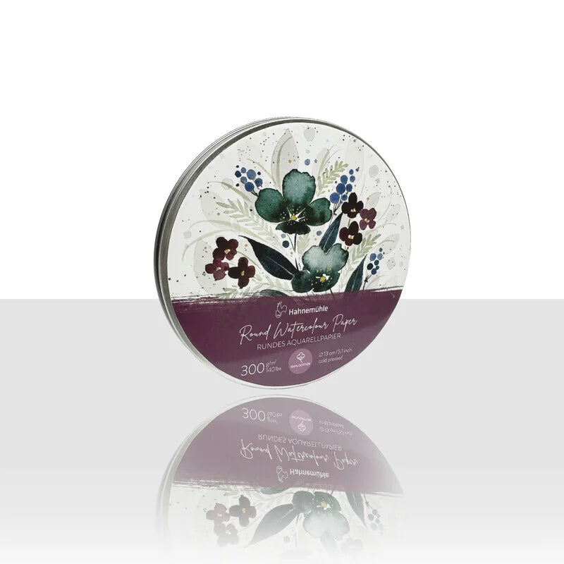 A round metal tin on a white background with a purple and green floral design, reads 'Round Watercolour Paper' on the front.