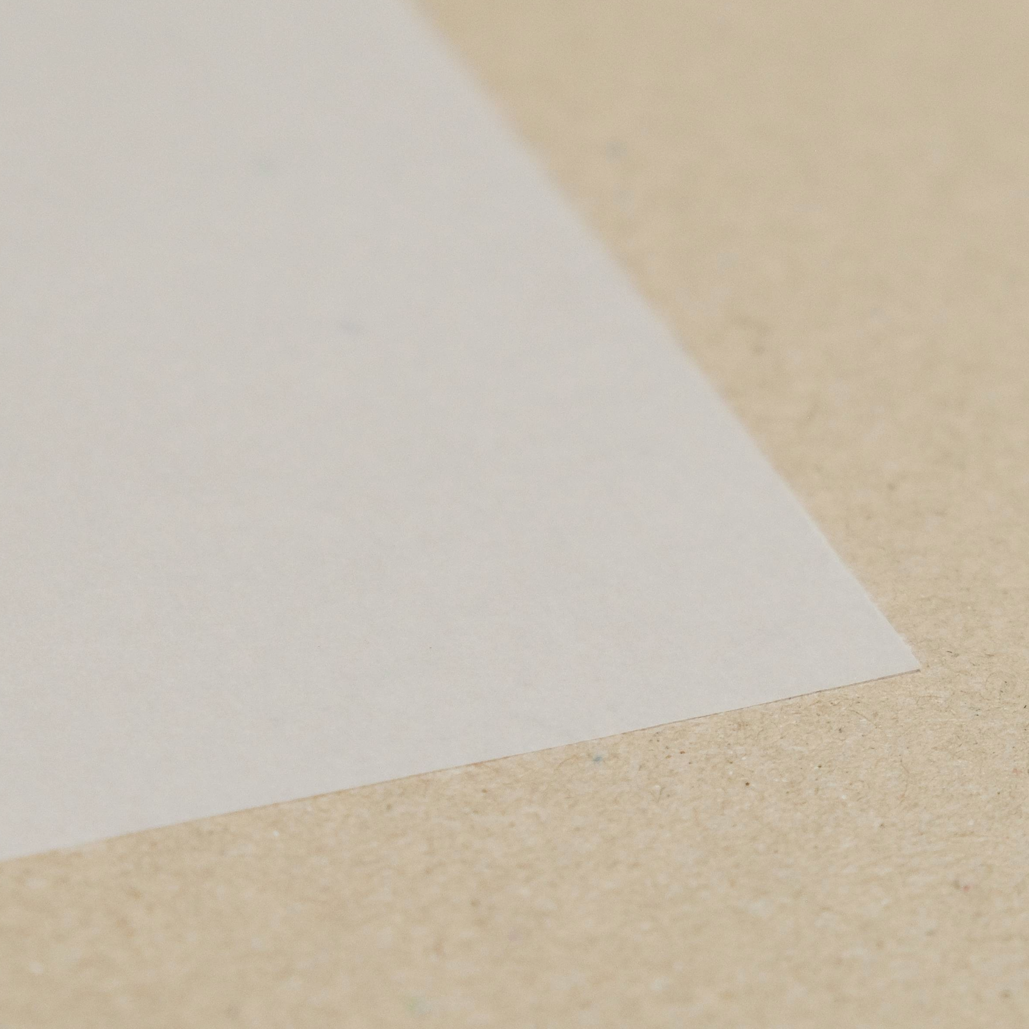 Close-up of a white transparent smooth surfaced paper on a brown surface.