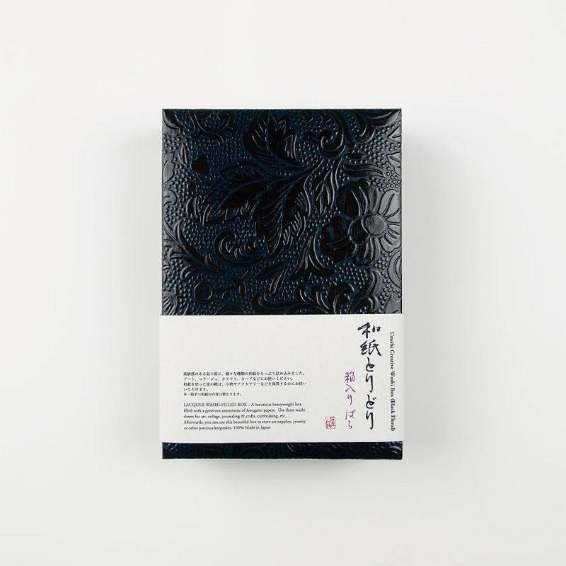 A black lacquered box with a flower design and a white strip of paper listing product details.