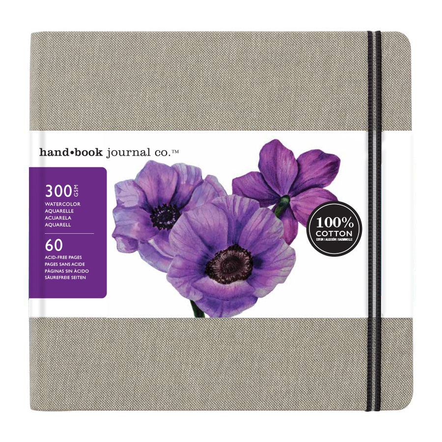 A square linen-covered watercolour journal with a beige textured cover and a floral designed packaging on a white background