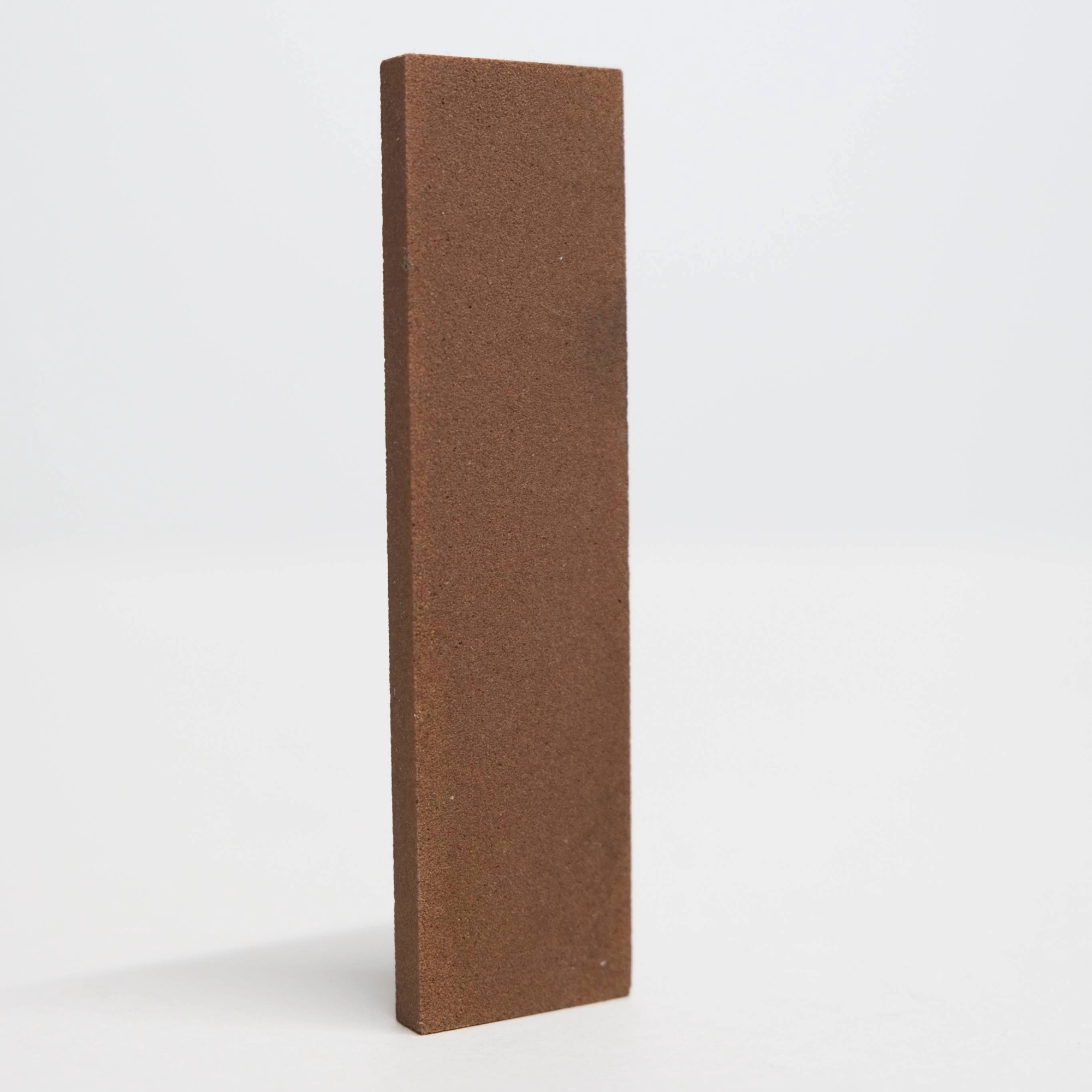 Brown rectangular sharpening block on a white background