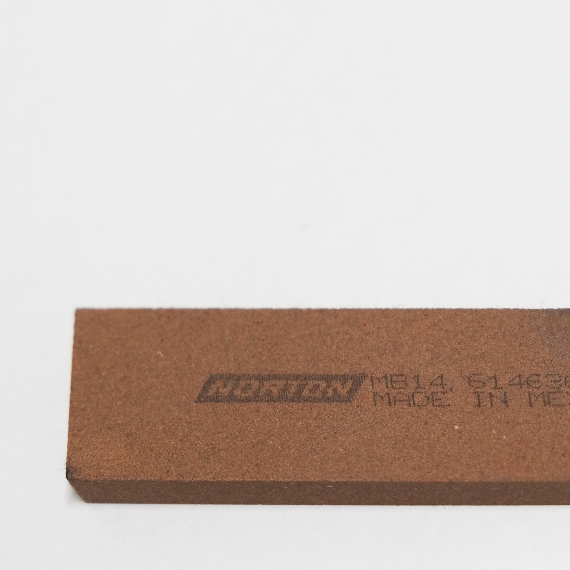 Brown sharpening block with 'Norton' branding and text on a white background