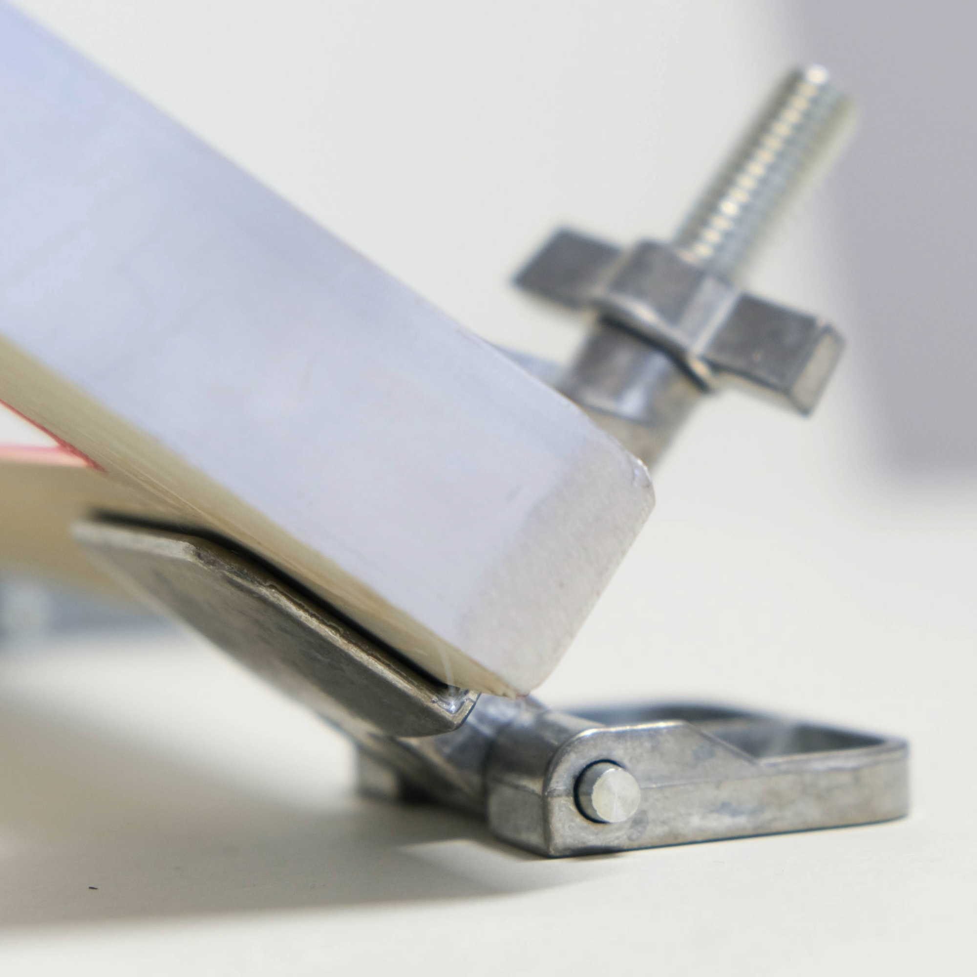 A speedball hinge clamp attached to an aluminium screen at the corner with the screen tilting up.