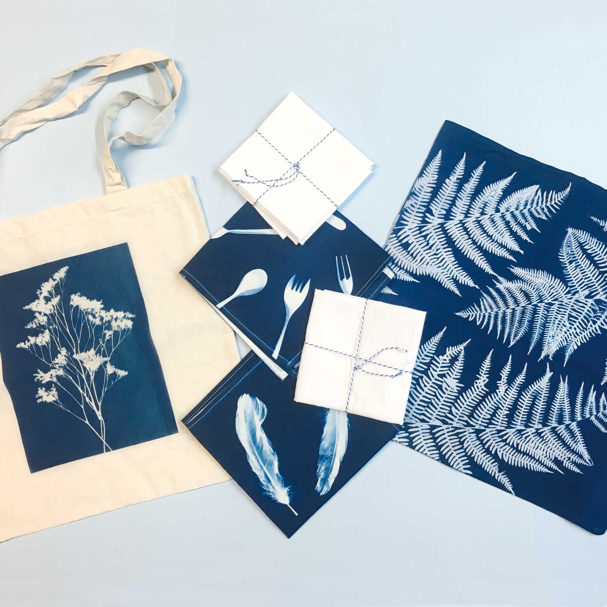 Examples of Cyanotype prints on fabric alongside unused textile bundles