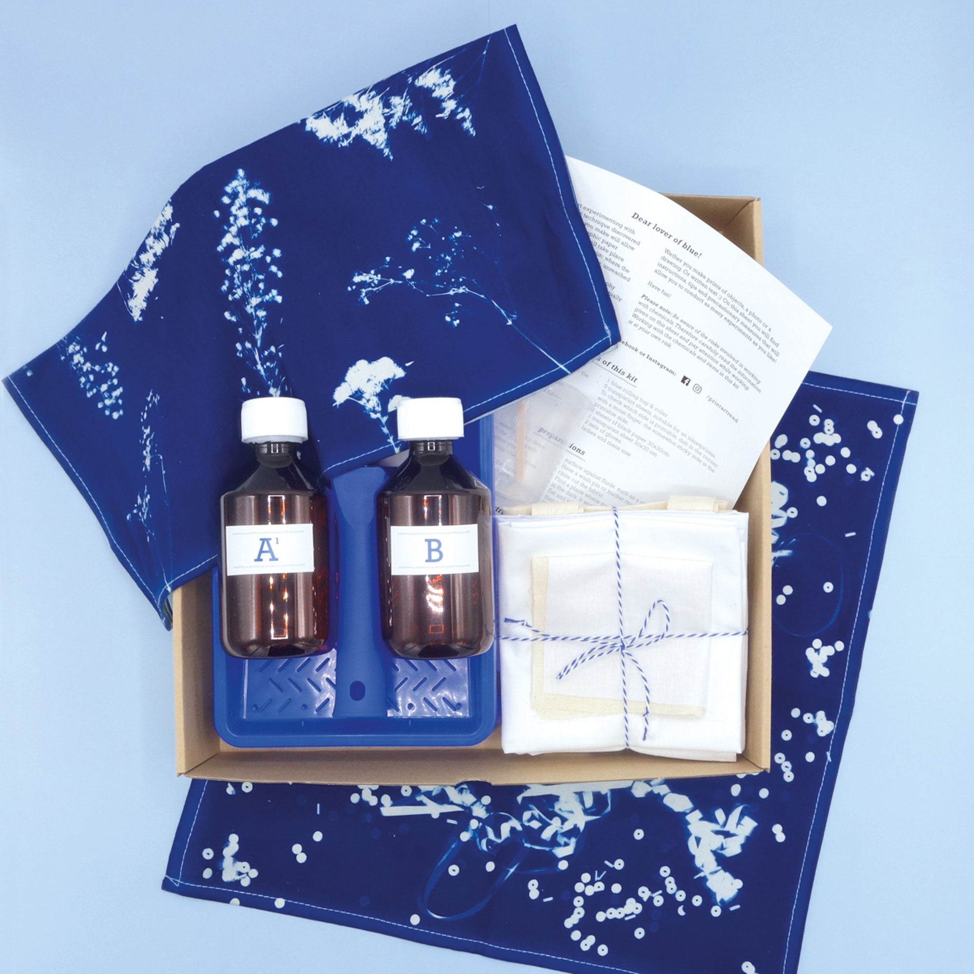 Contents of the Cyanotype Fabric Kit Box with examples of Cyanotype prints on Fabric 