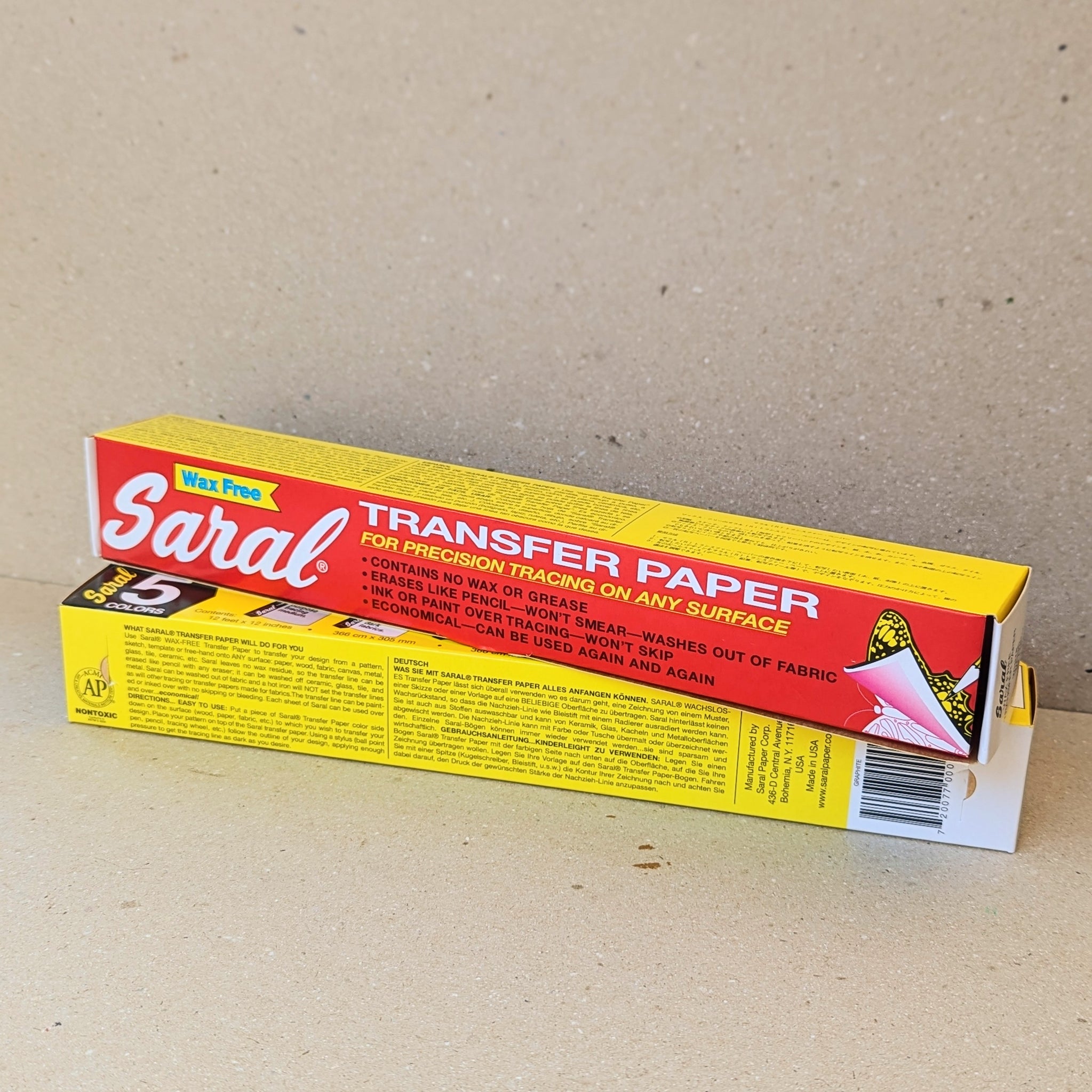 Two stacked boxes of Saral Transfer Paper with red and yellow packaging, placed against a beige background.