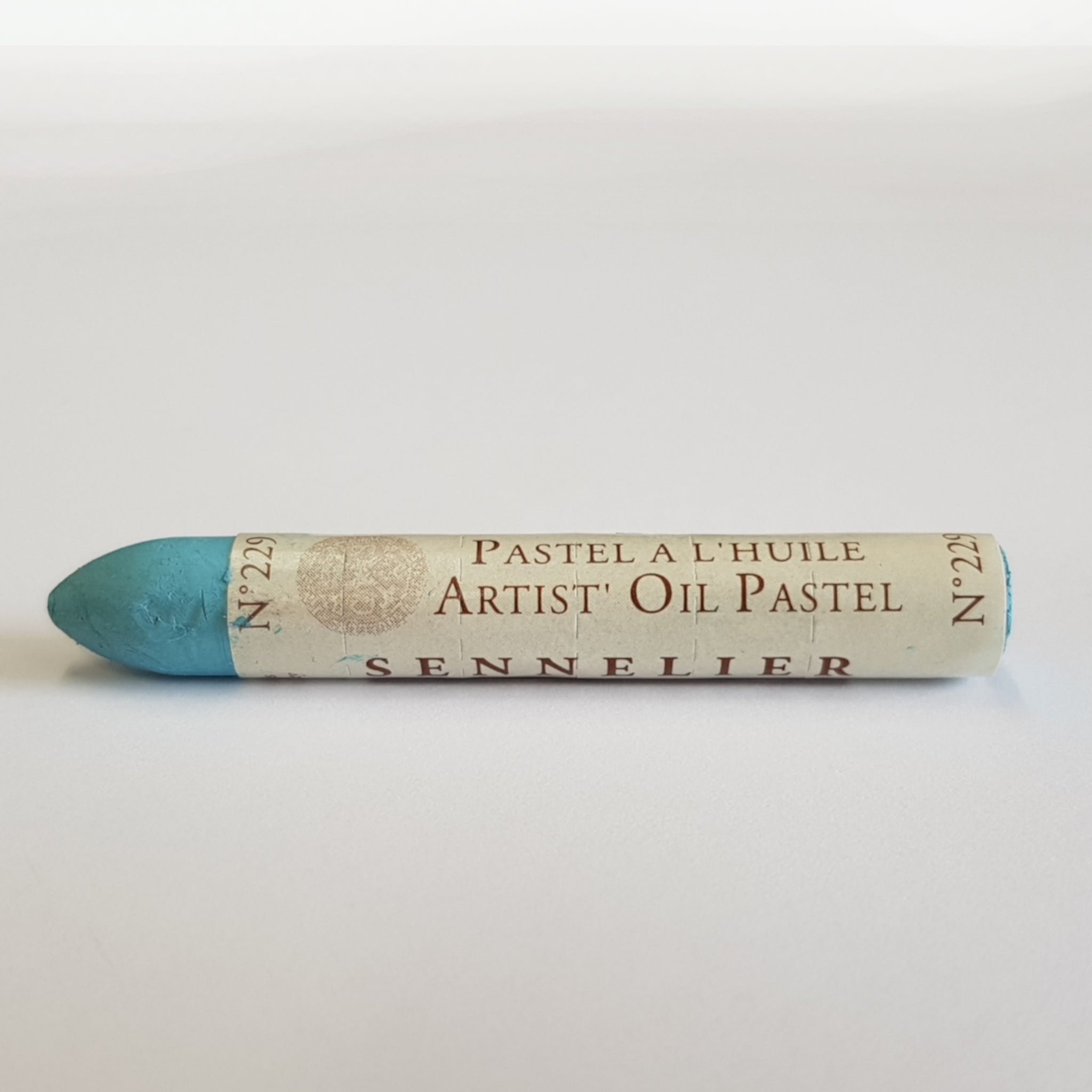 A single Sennelier oil pastel crayon against a white background, displaying the brand name and the words 'Artist Oil Pastel' on the wrapper.