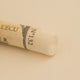 A close-up of a light orange Sennelier extra soft pastel. on the same coloured background, with the colour information printed on the paper wrap.