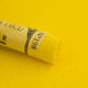 A close-up of a bright yellow Sennelier extra soft pastel. on the same coloured background, with the colour information printed on the paper wrap.