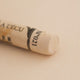 A close-up of a Sennelier extra soft pastel on a white background with the colour information printed on the paper wrap.