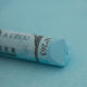 A close-up of a blue Sennelier extra soft pastel on the same coloured background, with the colour information printed on the paper wrap.