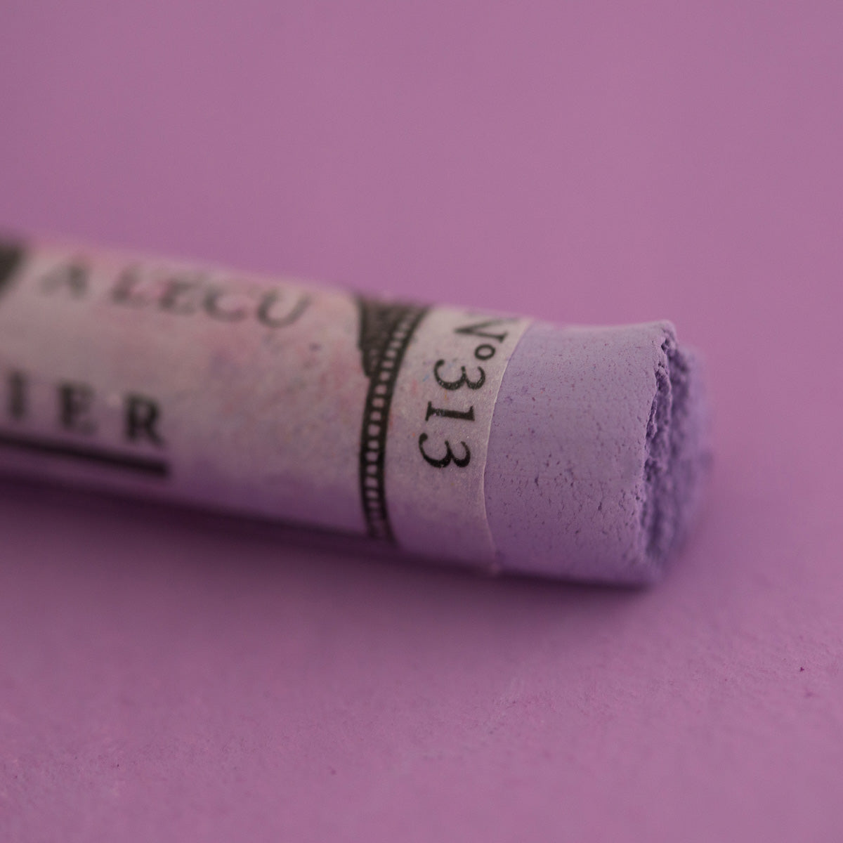 A close-up of a purple Sennelier extra soft pastel. on the same coloured background, with the colour information printed on the paper wrap.