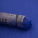  A close-up of a blue Sennelier extra soft pastel on the same coloured background, with the colour information printed on the paper wrap.