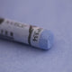 A close-up of a light blue Sennelier extra soft pastel on the same coloured background, with the colour information printed on the paper wrap.