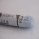  A close-up of a white Sennelier extra soft pastel on the same coloured background, with the colour information printed on the paper wrap.