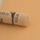 A close-up of a light yellow Sennelier extra soft pastel. on the same coloured background, with the colour information printed on the paper wrap.