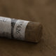 A close-up of a brown Sennelier extra soft pastel. on the same coloured background, with the colour information printed on the paper wrap.