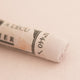 A close-up of a Sennelier extra soft pastel on a white background with the colour information printed on the paper wrap.