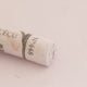 A close-up of a light purple Sennelier extra soft pastel with the colour information printed on the paper wrap.