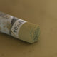 A close-up of a brown Sennelier extra soft pastel. on the same coloured background, with the colour information printed on the paper wrap.