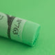 A close-up of a light green Sennelier extra soft pastel. on the same coloured background, with the colour information printed on the paper wrap.
