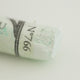 A close-up of a white Sennelier extra soft pastel. on the same coloured background, with the colour information printed on the paper wrap.
