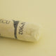 A close-up of a yellow Sennelier extra soft pastel. on the same coloured background, with the colour information printed on the paper wrap.