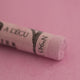 A close-up of a light purple Sennelier extra soft pastel. on the same coloured background, with the colour information printed on the paper wrap.