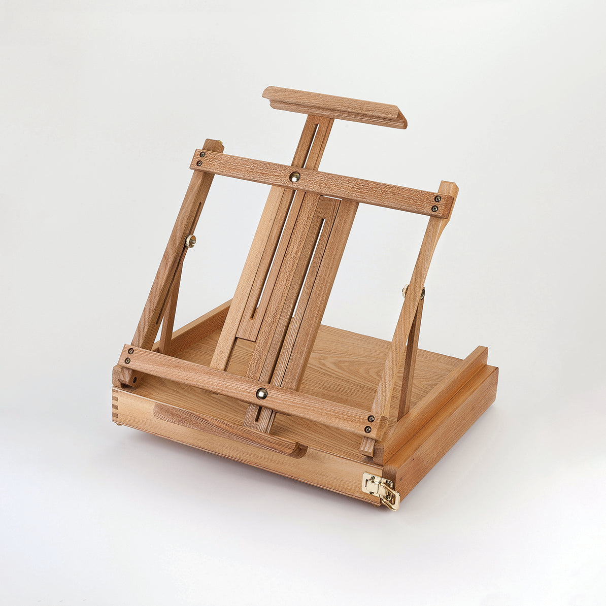 A small table top easel made of wood with a draw as its base and gold coloured metal claps and adjusting screws.