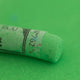 A close-up of a Sennelier large extra soft pastel on a bright green background.