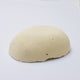 A half egg shaped pastel in a soft yellow  tone, sitting on a white background