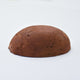 A half egg shaped pastel in a mid-brown tone, sitting on a white background