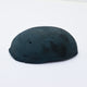 A half egg shaped pastel in a dark blue-green tone, sitting on a white background