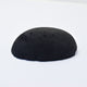 A half egg shaped pastel in a black tone, sitting on a white background